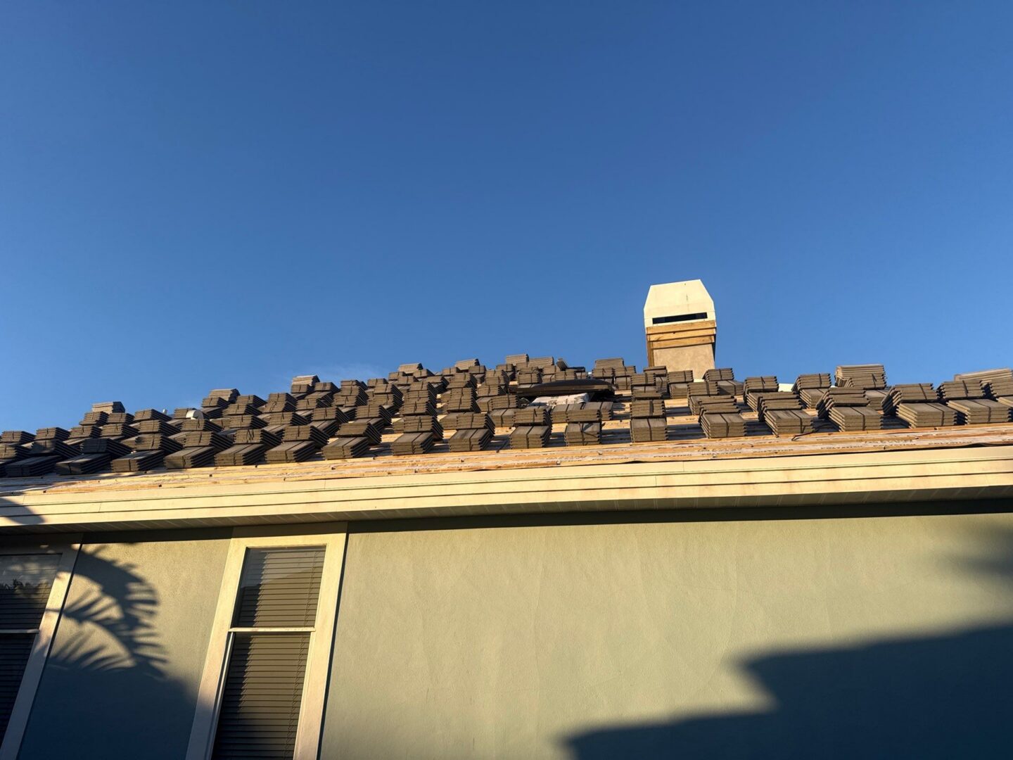 Roof with stacked tiles under blue sky