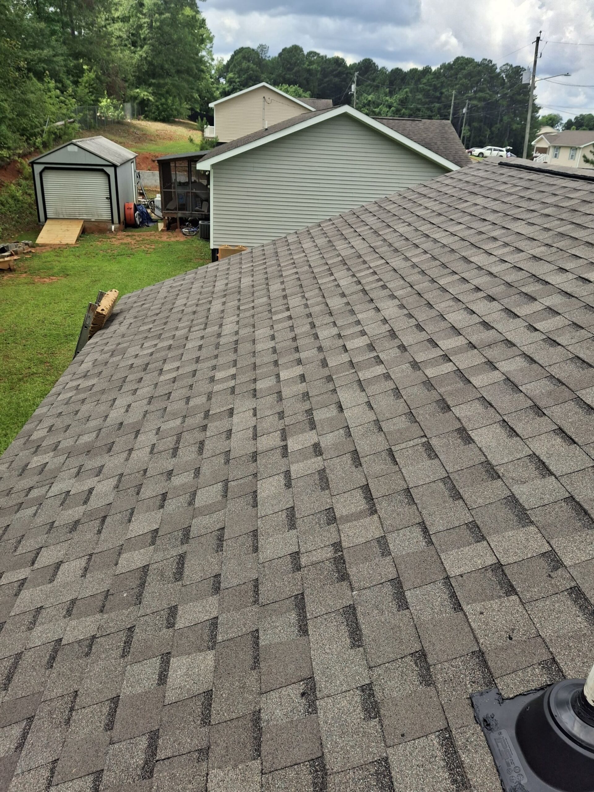 Residential roof with shingles and yard