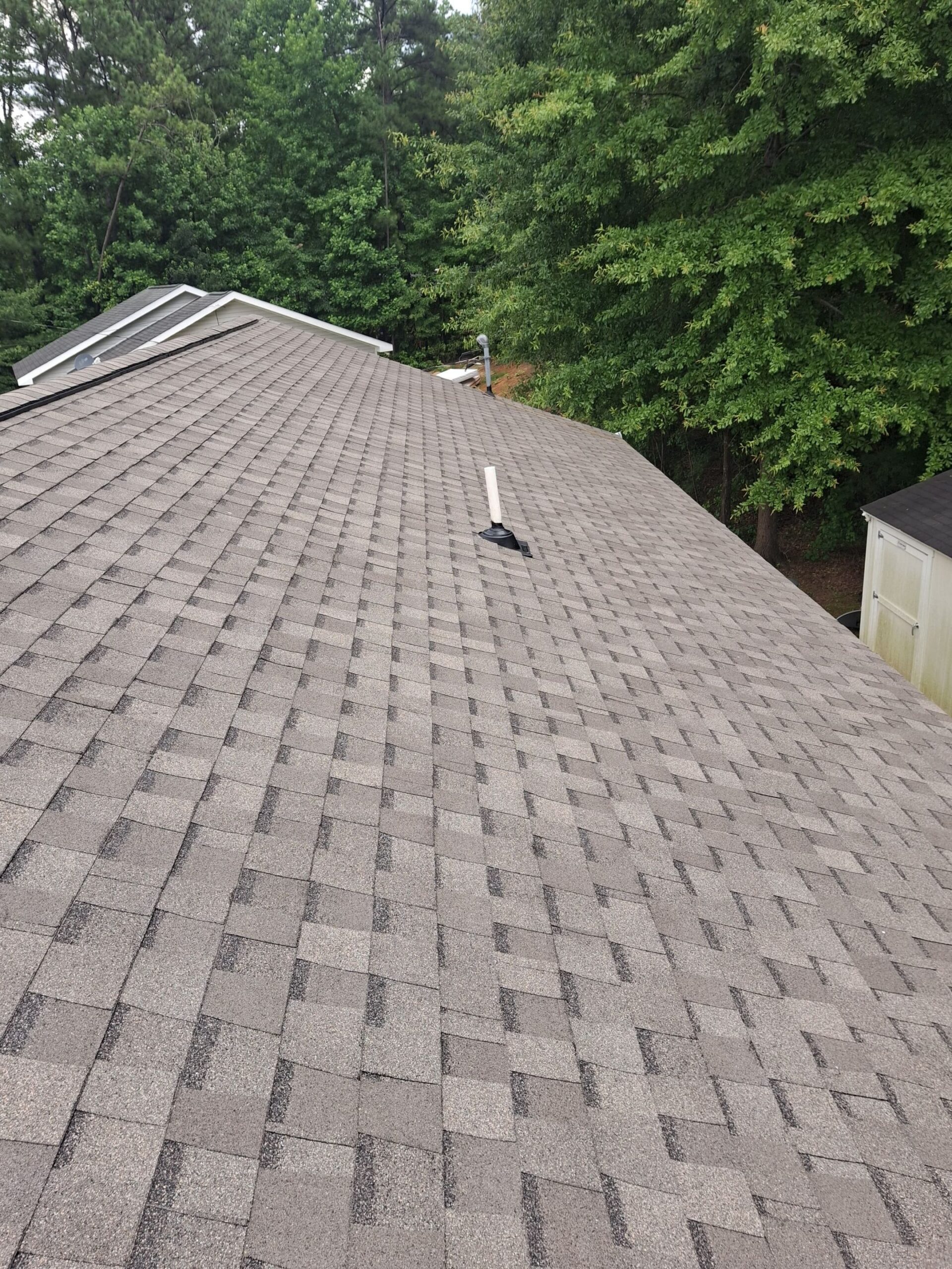 Asphalt shingles on sloped rooftop.